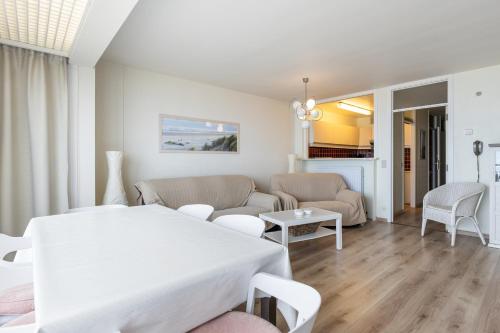 a white living room with a table and a couch at Horizon 0501 P in Sint-Idesbald
