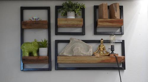 a wall with four wooden shelves on a wall at Casa Cayito Agua Dulce in Arecibo