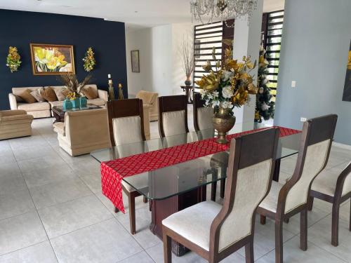 a dining room with a glass table and chairs at CASARENA Casa campestre con apartamentos independientes en los llanos in Villavicencio