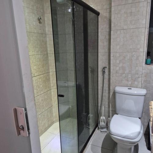 a bathroom with a glass shower with a toilet at Apartamento em Recife in Recife