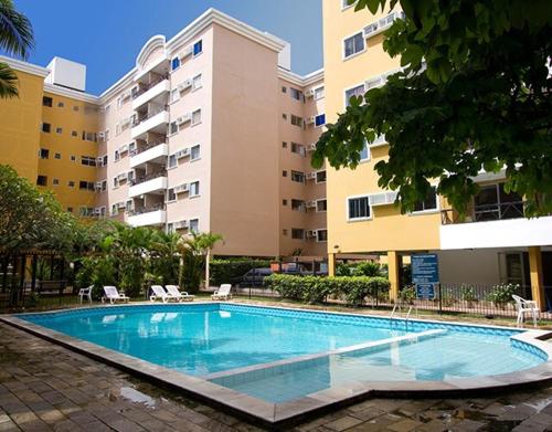 a swimming pool in front of a large building at Apartamento em Recife in Recife