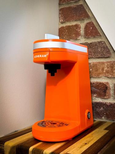 an orange machine sitting on top of a wooden table at Secluded Tiny Home in Exclusive Paris Mountain! in Greenville