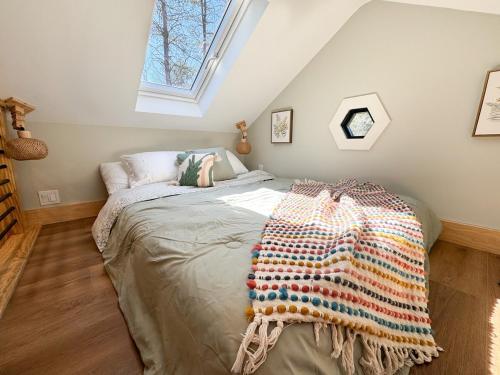 a bedroom with a bed with a crochet blanket on it at Secluded Tiny Home in Exclusive Paris Mountain! in Greenville