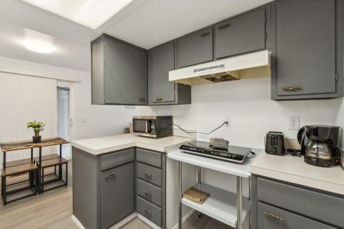 a kitchen with gray cabinets and white counter tops at Central Bellevue Retreat in Bellevue
