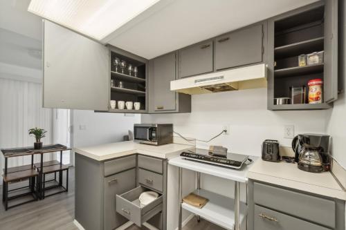 a kitchen with gray cabinets and white counter tops at Central Bellevue Retreat in Bellevue