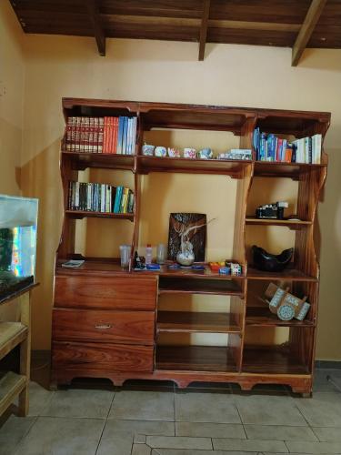 a wooden book shelf with a wooden dresser at Osa House - Drake Corcovado Tours in Drake