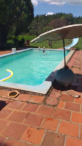a swimming pool with blue water on a brick floor at Sitio Preserva in São Borja