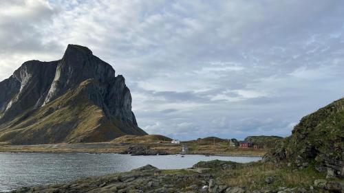 a mountain in the middle of a body of water at Prestholmen Værøy Lofoten in Værøy