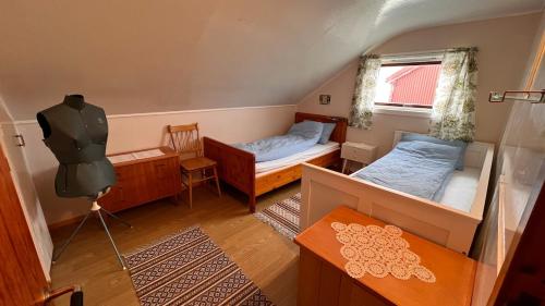 a small room with two beds and a window at Prestholmen Værøy Lofoten in Værøy