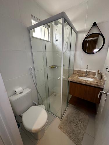 a bathroom with a toilet and a glass shower at Casa em condomínio fechado in Barreirinhas