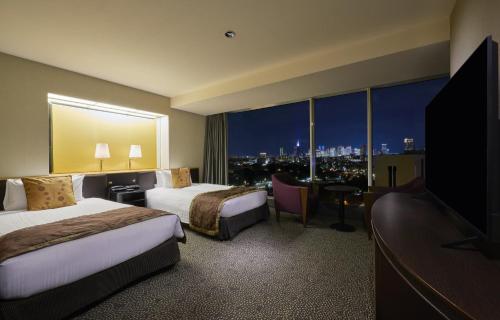 a hotel room with two beds and a large window at Hotel New Otani Tokyo The Main in Tokyo