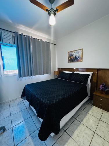 a bedroom with a bed and a ceiling fan at Apto aconchegante perto da praia in Vila Velha