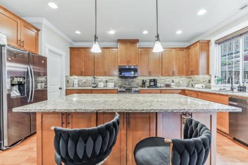 a kitchen with a large island with two bar stools at Spacious family and kids friendly house with backyard, fireplace, grill perfect for work crews in Beaverton