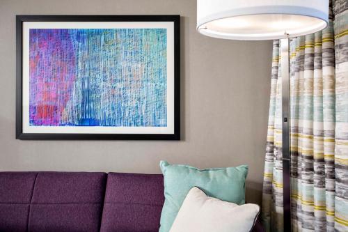 a living room with a purple couch and a painting at Crowne Plaza Atlanta - Midtown by IHG in Atlanta