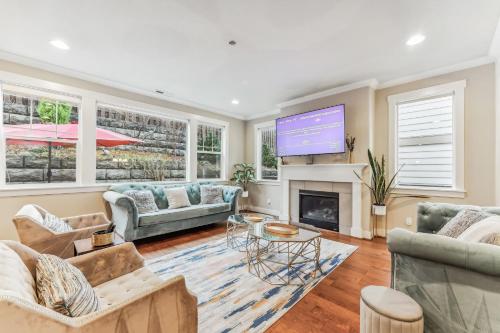 a living room with couches and a flat screen tv at Spacious family and kids friendly house with backyard, fireplace, grill perfect for work crews in Beaverton