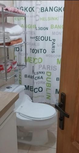 a bathroom with a toilet and a shower curtain at Cabaña-RIO Calle Calle in Valdivia