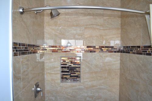 a shower stall with a glass door with a shower at Rex Motel in Ventura
