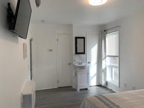 a white bedroom with a sink and a bathroom at Central Bellevue Retreat in Bellevue