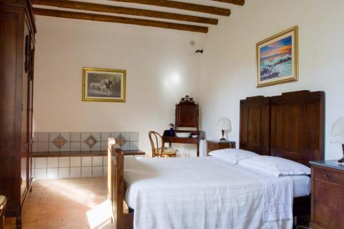 a bedroom with a white bed and a desk at Casale Stagnone in Marsala
