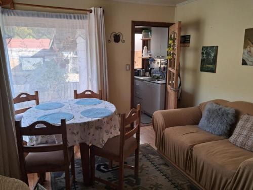 una sala de estar con una mesa y un sofá en Cabaña-RIO Calle Calle, en Valdivia