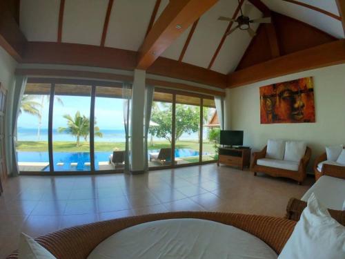 a living room with a view of the ocean at MJ Beautiful sunset beach house in Ban Na We