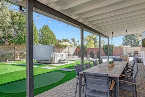 a patio with a table and chairs and a large screen tv at 49th St in Phoenix