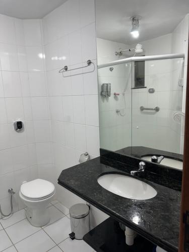 a bathroom with a sink and a toilet at Arraial do cabo loft prainha in Arraial do Cabo