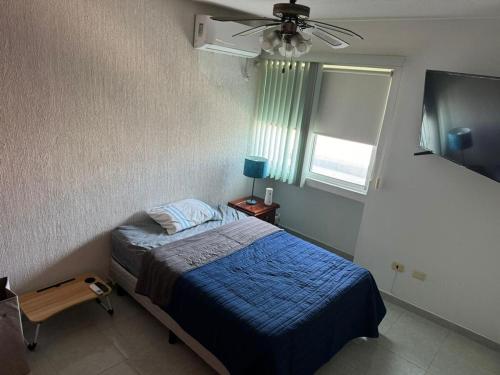 a bedroom with a bed and a ceiling fan at Departamento céntrico en Boca del Rio con alberca in Boca del Río
