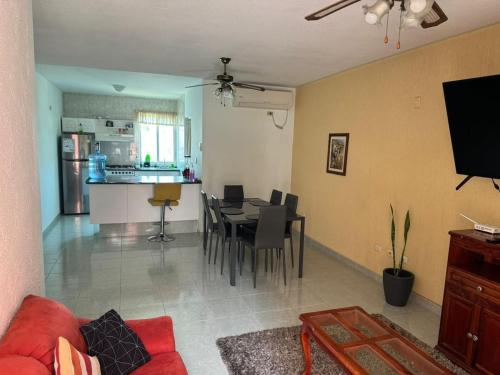 a living room and kitchen with a table and chairs at Departamento céntrico en Boca del Rio con alberca in Boca del Río