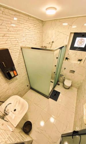 a bathroom with a shower and a sink and a toilet at Dreams By Mon in Al Karnak