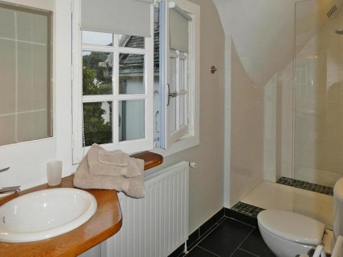 Un baño con lavabo, inodoro y ventana. en Charming Home in Carnac near Sandy Beach, en Carnac