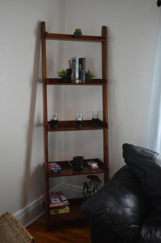 a book shelf with books and plants on it at Downtown Lima 1 Bdrm Haven! in Lima