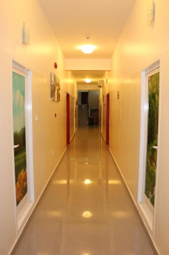an empty hallway in a building with white floors and windows at Al Karam Hotel Apartment in Nizwa