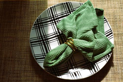 a green napkin on a plate on a table at Downtown Lima 1 Bdrm Haven! in Lima