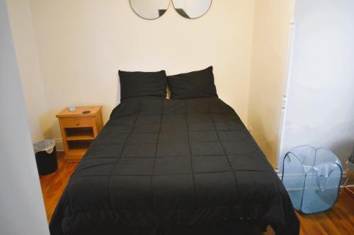 a bedroom with a black bed with a blue backpack at Downtown Lima 1 Bdrm Haven! in Lima