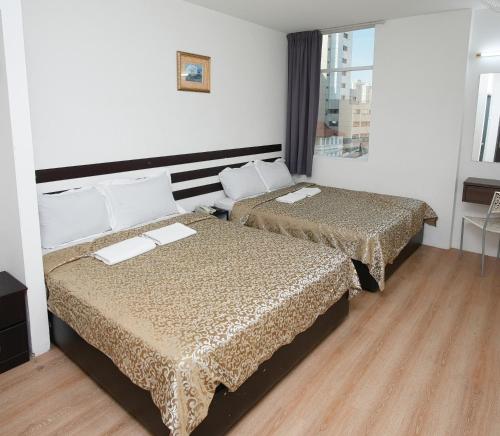 a hotel room with two beds and a window at Grand Inn Hotel - Macalister Road in George Town