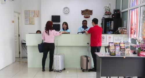 a group of people standing at a counter at Grand Inn Hotel - Macalister Road in George Town