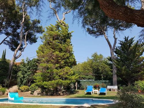a yard with two chairs and a swimming pool at Tamariu Chalet, 3 Bedroom in main house and self contained unit in Tamariu