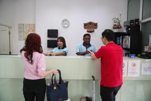 a man and a woman standing at a counter at Grand Inn Hotel - Macalister Road in George Town
