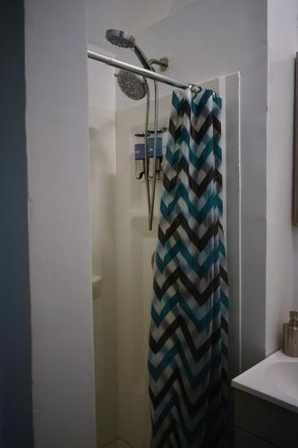 a bathroom with a shower with a striped shower curtain at Lima Downtown 1 Bdrm Oasis in Lima