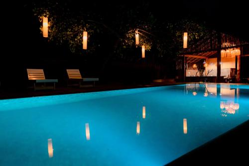 a blue swimming pool at night with lights at Hilltop villas in Mirissa