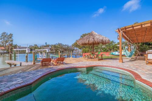 a swimming pool with a patio and a swing at Waterfront Cove Paradise with Pool and Canoes - Dolphin and Manatee Viewpoint in Largo