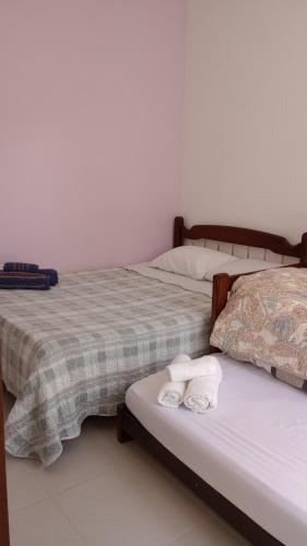 two beds sitting next to each other with towels on them at Hospedagem, Pouso Famíliar Paraty in Paraty