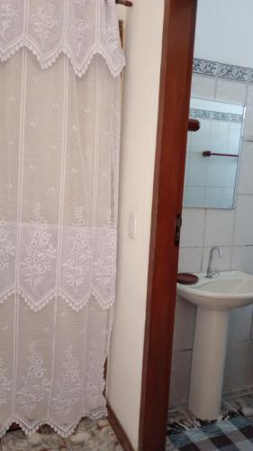 a bathroom with a shower curtain and a sink at Hospedagem, Pouso Famíliar Paraty in Paraty