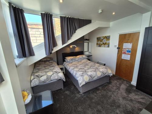 a bedroom with two beds and a window at Miricia Guest House in Scarborough