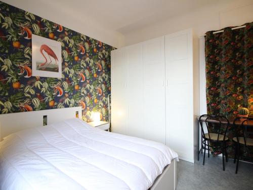 - une chambre avec un lit et un mur coloré dans l'établissement Appartement F2 avec ascenseur et Wi-Fi au centre du Mont-Dore - FR-1-415-44, à Le Mont-Dore
