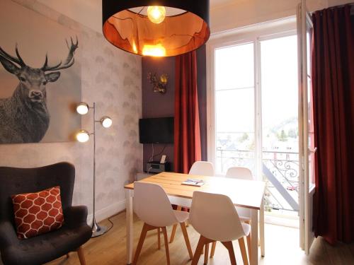 une salle à manger avec une table et une tête de cerf sur le mur dans l'établissement Appartement F2 avec ascenseur et Wi-Fi au centre du Mont-Dore - FR-1-415-44, à Le Mont-Dore