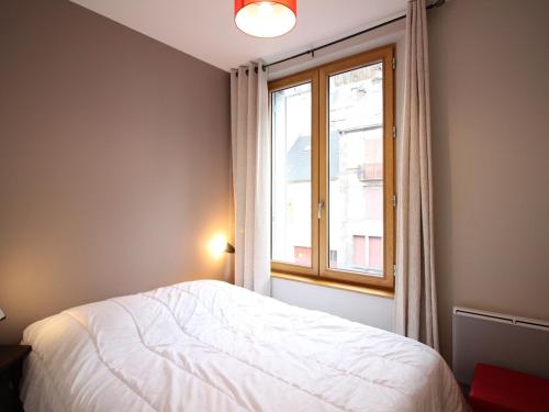 une chambre avec un lit blanc et une fenêtre dans l'établissement F2 bis au Mont-Dore, 200m du centre et Thermes, parking privé, animaux acceptés, 6 couchages - FR-1-415-69, à Le Mont-Dore