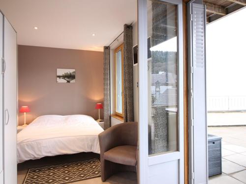 une chambre avec un lit et une chaise dans l'établissement Appartement Neuf 6 Couchages, Terrasse, Parking, WiFi - FR-1-415-67, à Le Mont-Dore