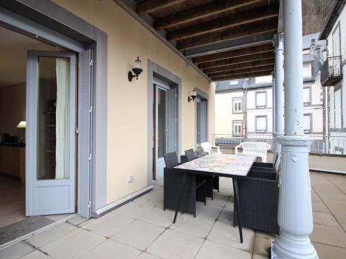 une salle à manger avec une table et des chaises sur un balcon dans l'établissement Appartement Neuf 6 Couchages, Terrasse, Parking, WiFi - FR-1-415-67, à Le Mont-Dore